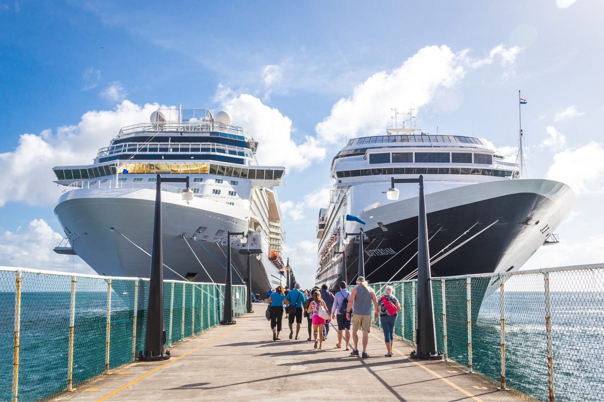 Two cruise ships at the pier with passengers walking ashore